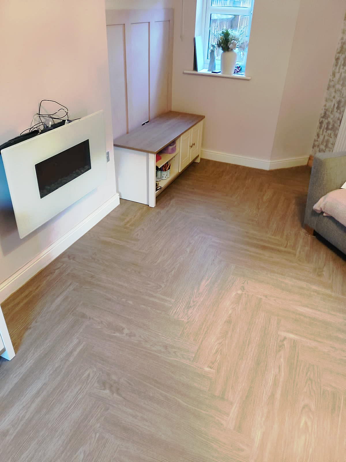 Herringbone laminate flooring laid across a living room